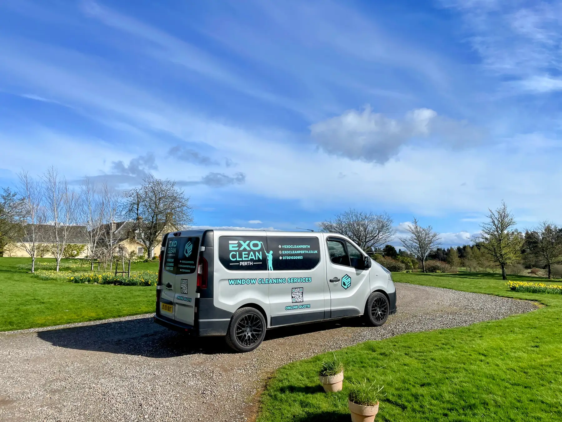 The ExoClean van parked on a gravel drive under a bright blue sky