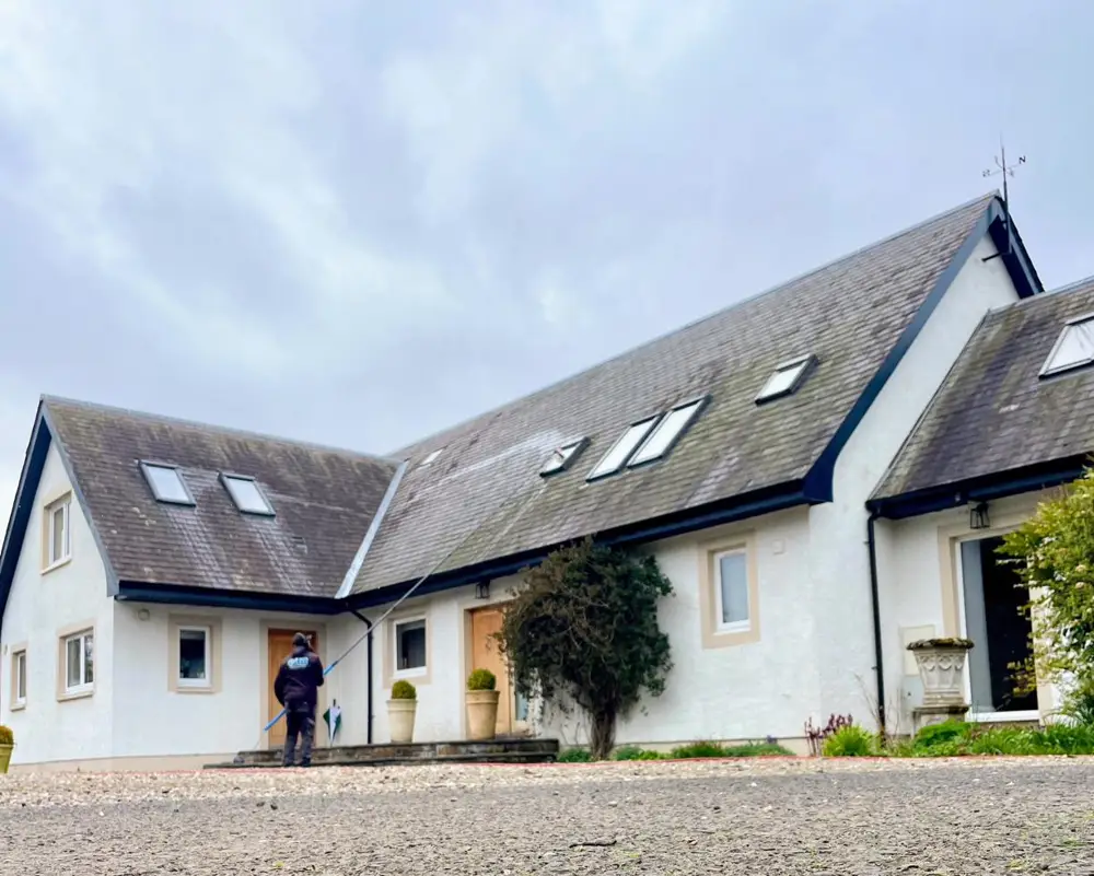 Craig cleaning a large white cottage